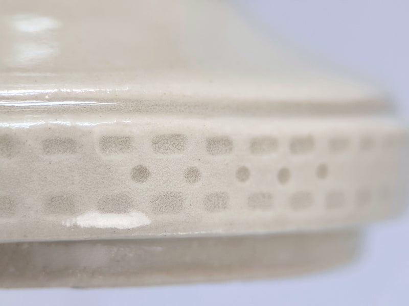 Close-up of base and foot detail on cream ceramic pet memorial urn