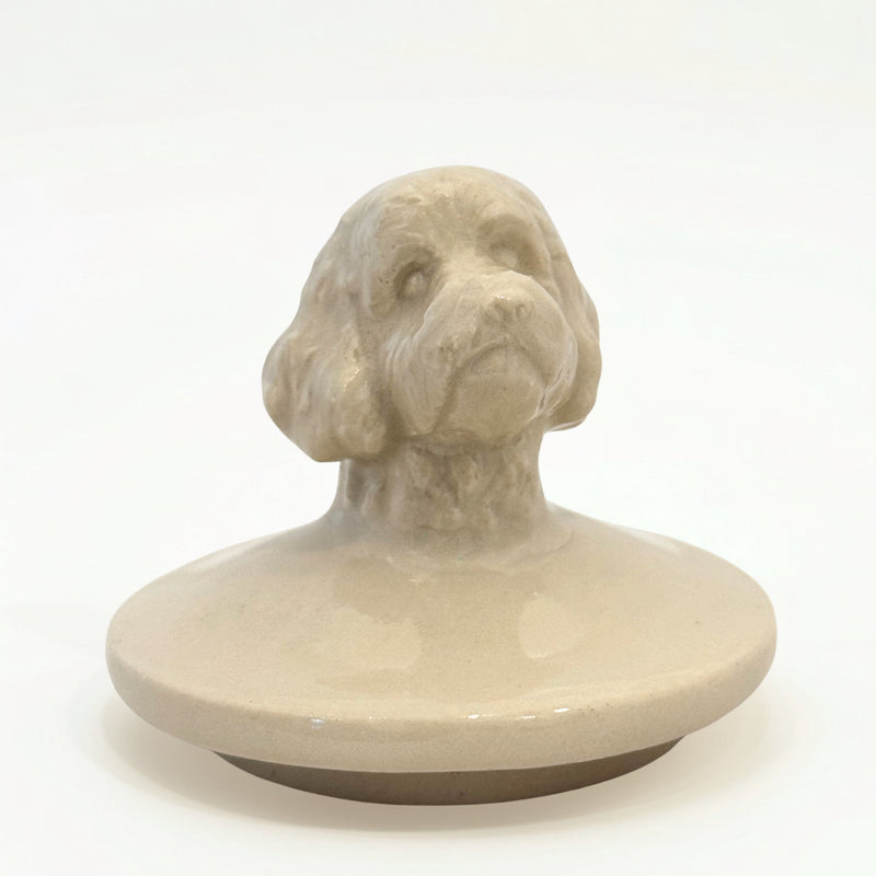 Close-up of hand-sculpted Doodle dog figure on ceramic urn lid