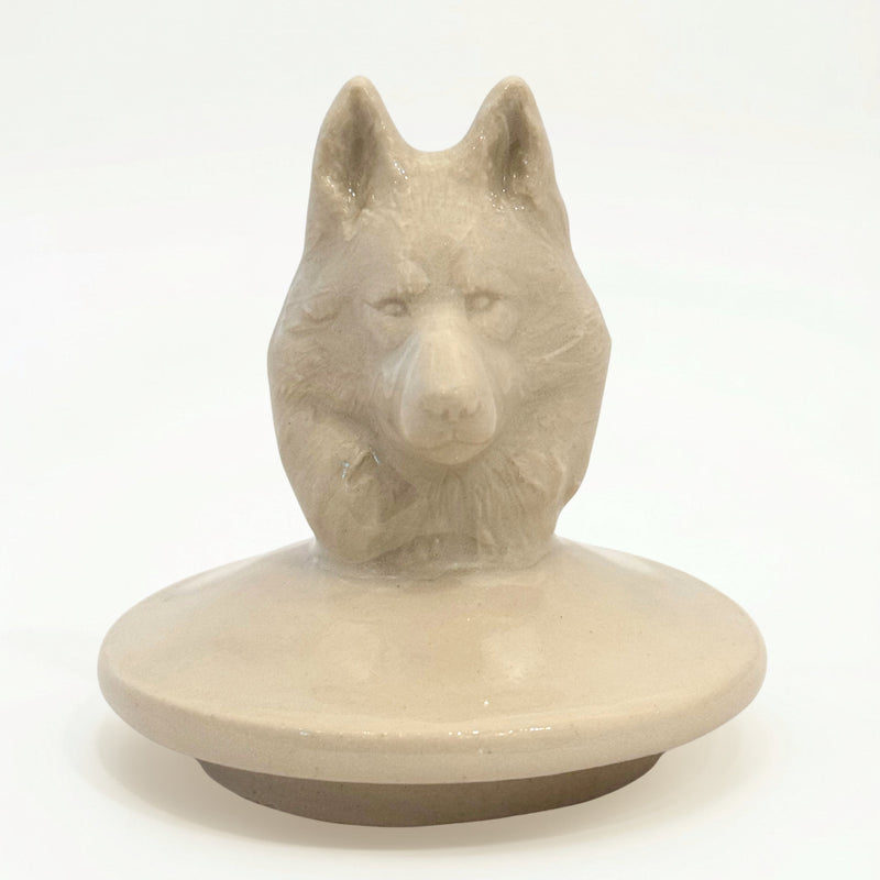 Close-up of hand-sculpted Husky dog figure on ceramic urn lid