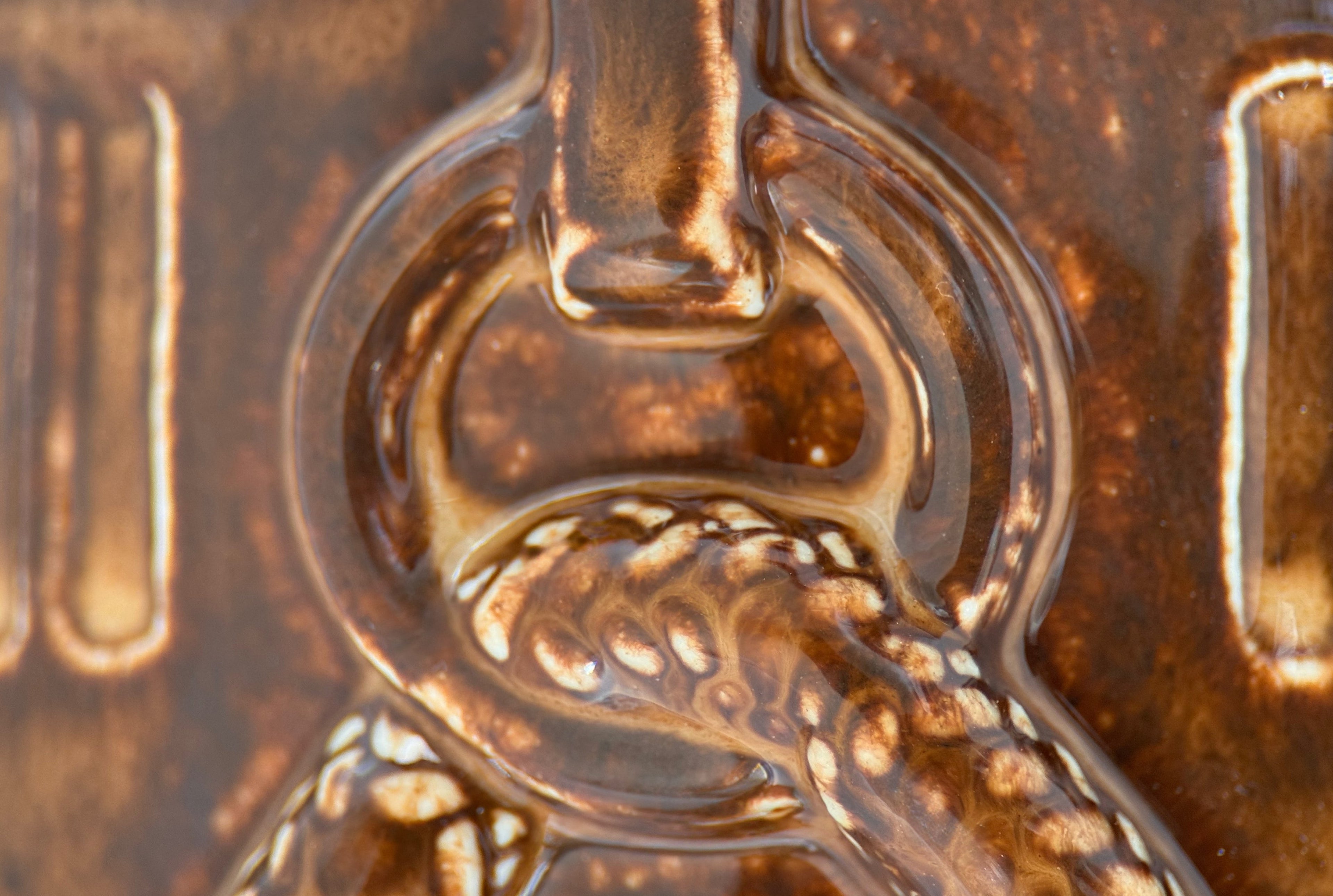 Close-up of collar ring relief detail on ceramic pet memorial urn, tawny brown glaze